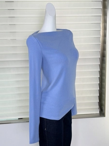 Détail d'un haut en tricot bleu clair ajusté avec col bateau sur un mannequin