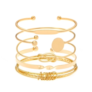 Detail van een zesdelige vergulde armbandenset met hartslot en knoopvormige bedels