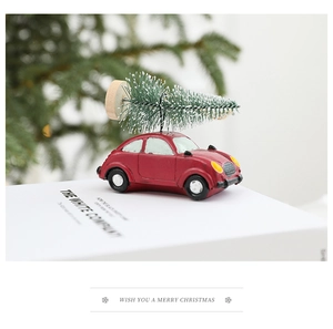 Macro shot of a red vintage car ornament with a snowy mini pine tree on a Christmas tree