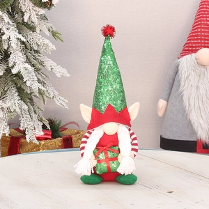 Christmas gnome decoration with green sequins and white braids on a festive table