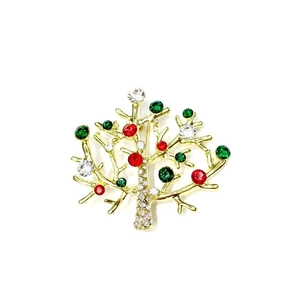 Detail einer goldenen Weihnachtsbaum-Brosche mit roten und grünen Straßsteinen