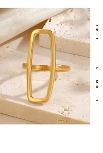 Detail of 18K gold plated rectangular hollow ring on stone background with silk fabric