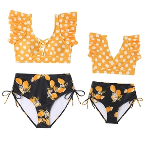 Matching yellow polka dot ruffle tops and lemon print bikini bottoms for family sets