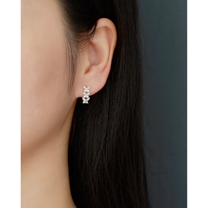 Detail of silver S925 butterfly stud earring with sparkling crystals on ear lobe
