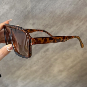 Close-up of wide leopard print sunglasses frame with brown gradient lenses and thick temples