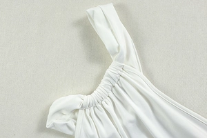 Close-up of white ruched shoulder details and refined pleated texture on slim dress