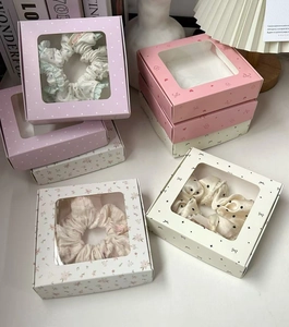 Detailed view of floral scrunchies in elegant square window display gift packaging box