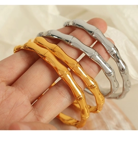 Detailed close-up of gold and silver bamboo style bracelets with a polished finish