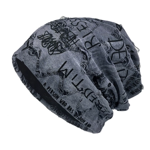 Distressed dark grey knitted slouchy beanie with graffiti lettering for street style