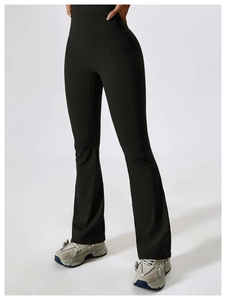 Detailed view of high-waisted wide waistband and flared leg of black yoga pants