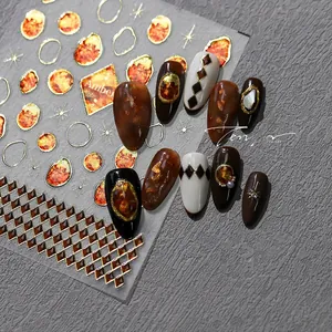 Detailed amber nail art stickers with gold foil geometric patterns and starry accents