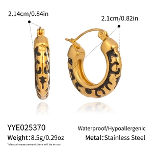 Detail view of gold hoop earrings with leopard pattern and precise size measurements