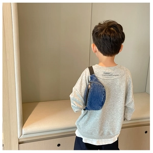 Rear view of a child wearing a casual blue denim crossbody bag over a grey sweatshirt