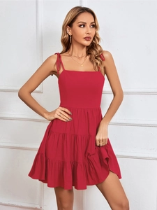 Detailed close-up of layered ruffle hem on red sleeveless strap vacation dress