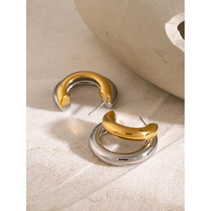 Two-tone 18k gold and silver layered C-shape chunky hoop earrings on stone display