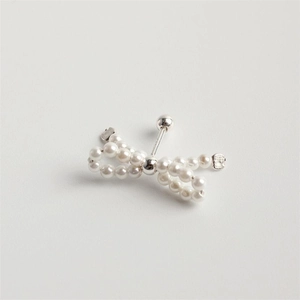 Macro shot of 925 sterling silver bow stud earring featuring delicate hand-woven pearls
