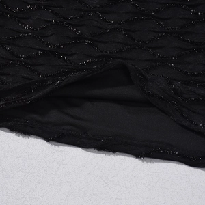 Gros plan sur un tissu noir ondulé avec détails en fil d'argent et doublure intérieure fine