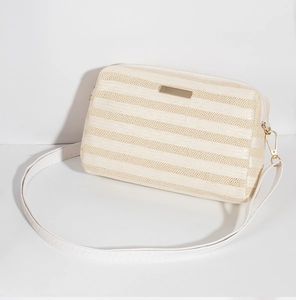 Macro shot of off-white woven texture and gold metal plate detail on crossbody bag