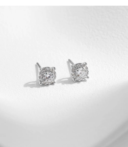 Macro shot of silver stud earrings featuring round moissanite with halo setting design