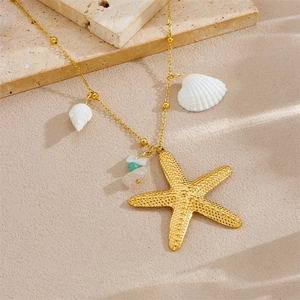 Gold starfish necklace with white shells and turquoise beads on beach stones