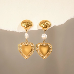 Detail of gold heart earrings with shell studs, baroque pearl, and crystals