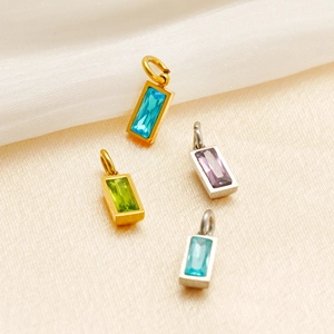 Detailed view of rectangular birthstone pendants in gold and silver finishes