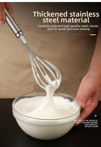 Detail of 304 stainless steel whisk mixing heavy cream in a clear glass bowl