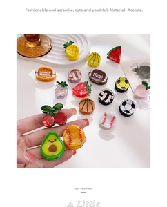 Nahaufnahme bunter Mini-Haarklammern aus Acetat in Frucht- und Sportdesigns