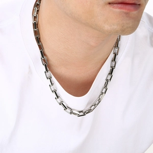 Detail of 9mm thick polished silver-tone rectangular link chain necklace on model