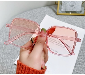 Detail of pink transparent square sunglasses frame with gradient lenses and rice nail decor