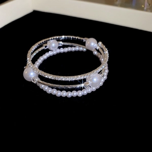 Dettaglio del bracciale multistrato in argento con perle bianche e pavé di diamanti lucidi