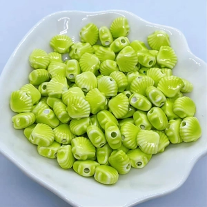 Detailed view of light green shell-shaped ceramic beads for DIY jewelry making
