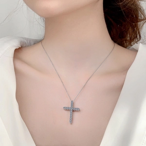 Moissanite cross necklace in 925 sterling silver worn by a model on white clothes