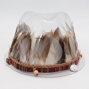 Detail of bohemian hat band with feathers, woven straps, and metal coin charms