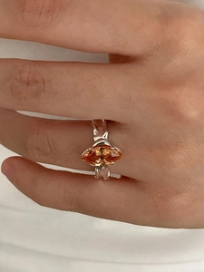 Macro shot of 925 silver ring with marquise cut amber zircon on a finger