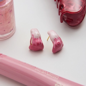 Detail of pink and white enamel melting drop earrings with gold-plated stainless steel studs