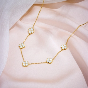 Minimalist gold titanium steel necklace featuring five white shell clover charms on pink silk