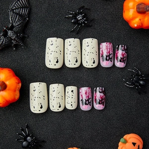 Halloween black and red press-on nails with BOOM letter art and spooky decorative motifs