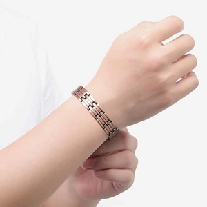 Men's wide copper magnetic bracelet with wheat pattern design worn on a wrist