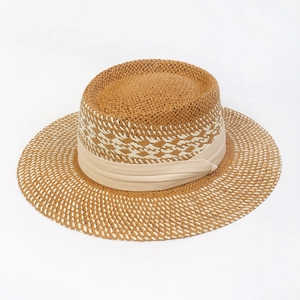 Macro detail of brown and white hollow woven straw texture on a flat top sun hat
