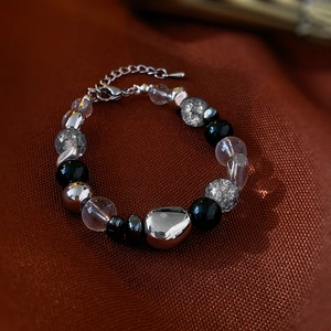 Detail of beaded bracelet with faux cat eye stones and metallic beads on fabric