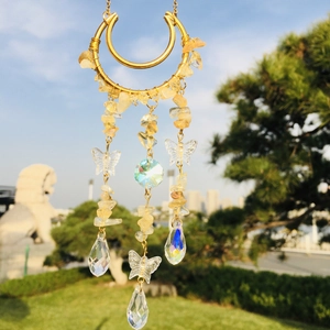 Detailed close-up of golden moon suncatcher with yellow crystals and butterfly pendants