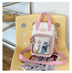 Detail view of pink and white ita bag with clear display window on a yellow chair