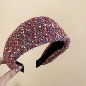 Detail of red tweed headband with golden threads and soft textured fabric finish