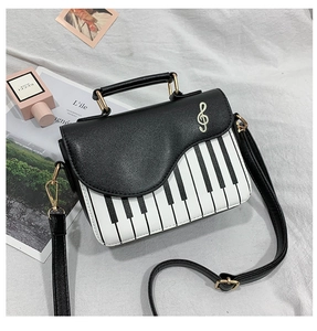 Detail of creative piano bag showing gold clef embroidery and black and white keys