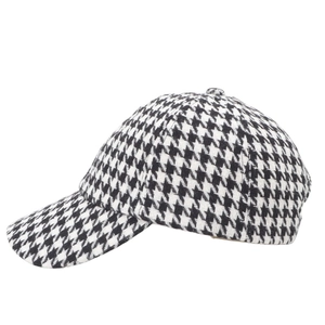 Close-up of black and white houndstooth fabric texture on a six-panel baseball cap