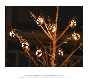 Detail of warm white reindeer LED string lights hanging on rustic wooden branches