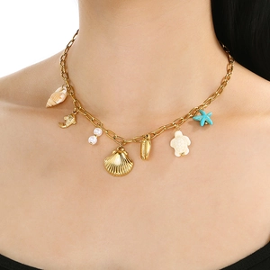 Detail of gold necklace with ocean charms like starfish, shells, and pearls on a model