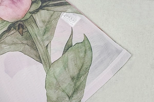 Detailed macro view of high-quality stitching and washing labels on floral fabric