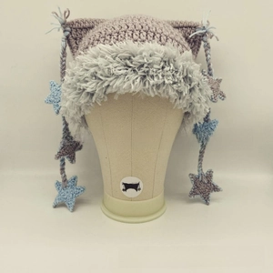 Detail of handmade lavender knit cat ear hat with stars and grey faux fur trim